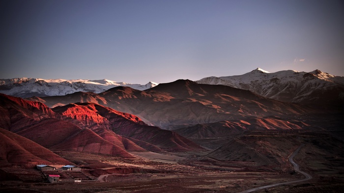Red mountains and snow-capped peaks at sunset