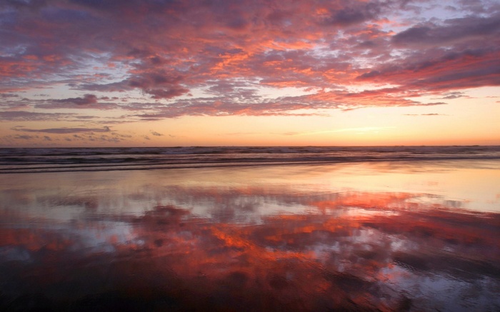 Sunset over the ocean with colorful clouds and reflections