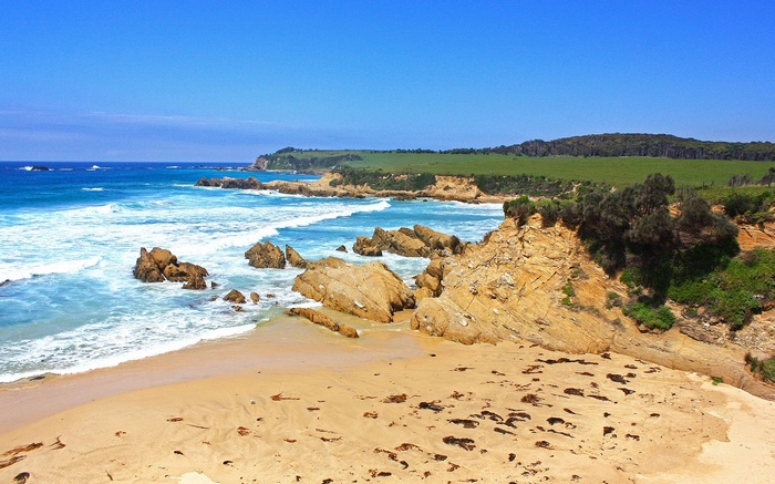 Rocky coastline with sandy beach and ocean waves