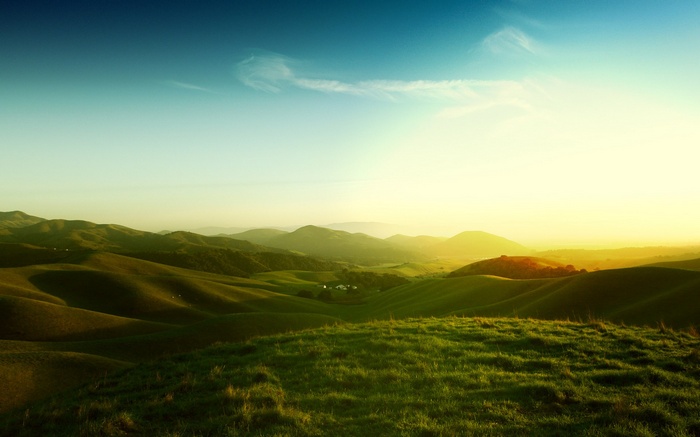 Rolling green hills under a bright sky