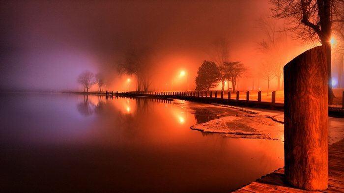 Foggy night by a lake with streetlights