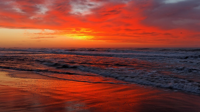 Ocean waves crashing on a beach at sunset