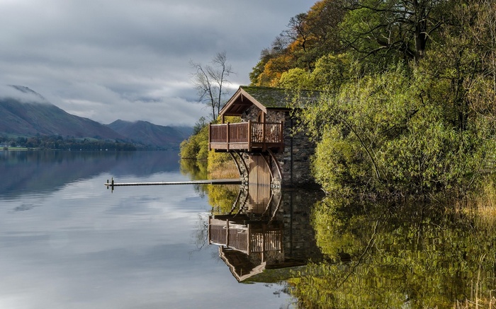 Boathouse on a lake with mountains and trees