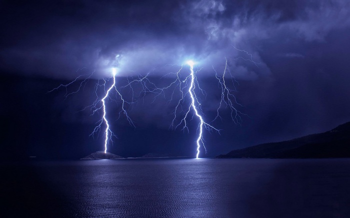 Lightning strikes over a dark body of water