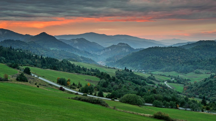 Mountain valley with winding road at sunset
