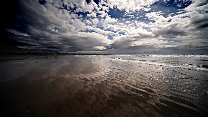 Beach with dramatic clouds and ocean waves