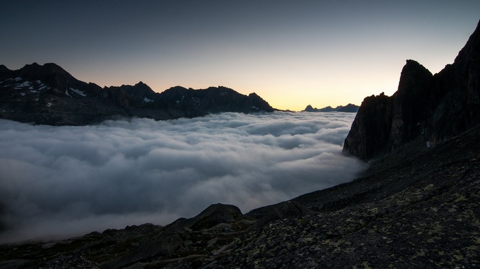 Mountain peaks above clouds at dawn