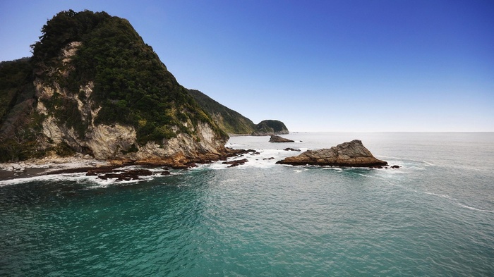Rocky coastline with green hills and blue ocean