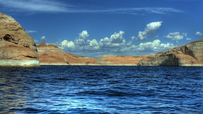 Lake Powell with sandstone cliffs and blue sky
