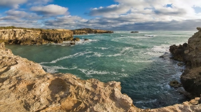 Rocky coastline with turquoise ocean and cloudy sky