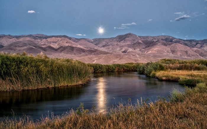 River and mountains under a bright moon
