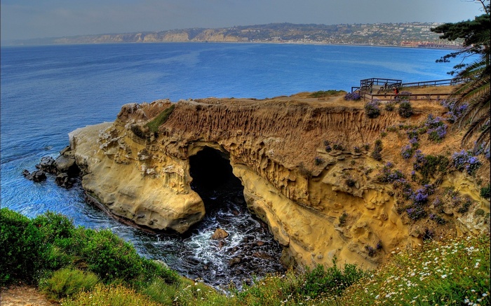 Cave entrance in a cliff overlooking the ocean