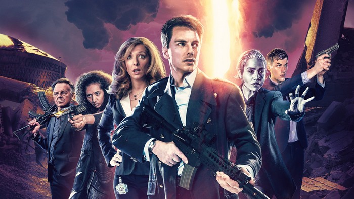 Torchwood characters with weapons in front of destruction