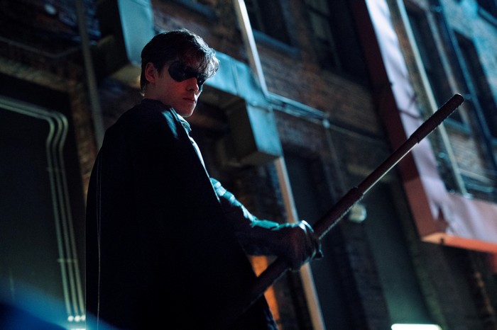 Robin from Titans holding a staff
