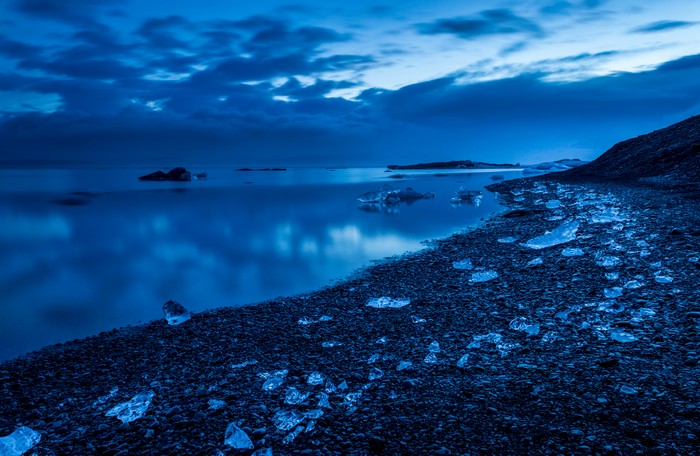 Icebergs on a rocky shore at dusk