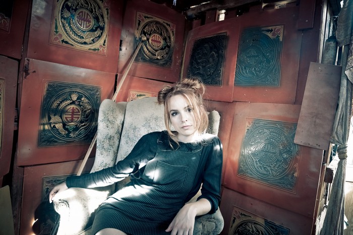 Bridgit Mendler sitting in an armchair