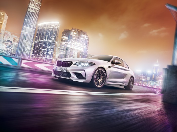BMW M2 driving through a city at night