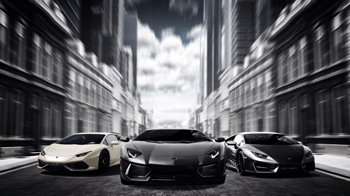 Three Lamborghinis driving down a city street