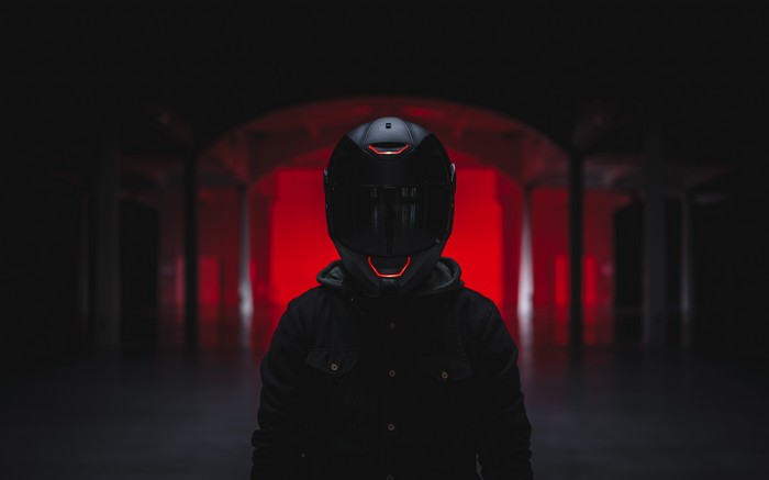 Man in black helmet and jacket with red lights