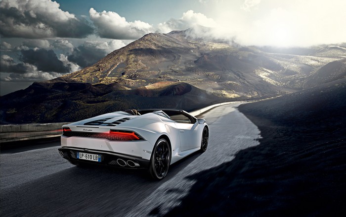 White Lamborghini Huracan driving on a mountain road