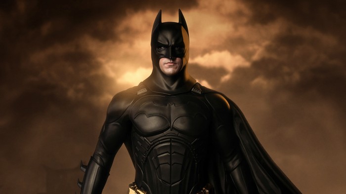 Batman in a black suit with a cape