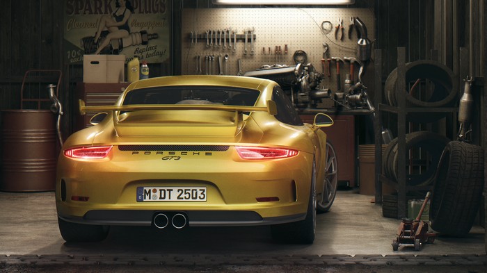 Yellow Porsche GT3 in a garage with tools