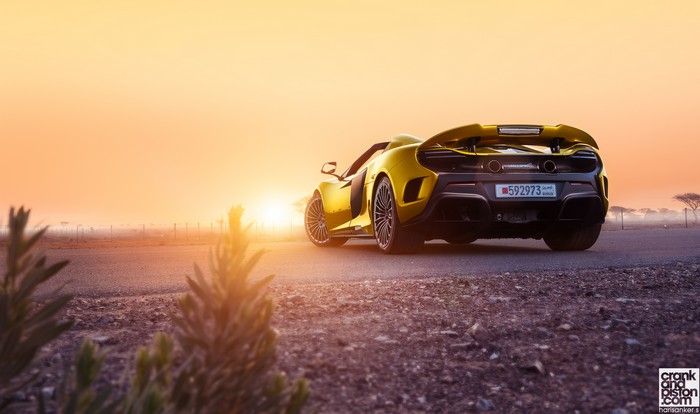 Yellow McLaren sports car on a road at sunset