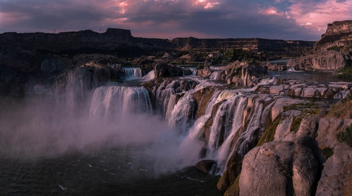 Majestic Waterfall Cascading Over Rocky Cliffs at Sunset 4K