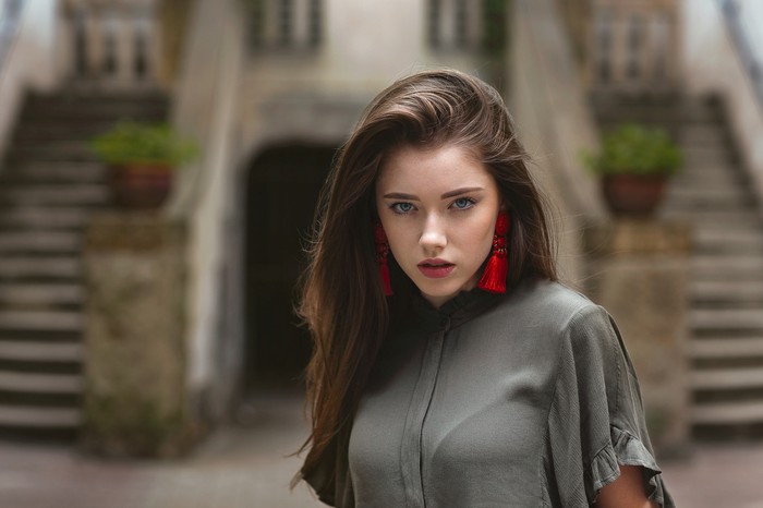 Woman with long brown hair and red earrings