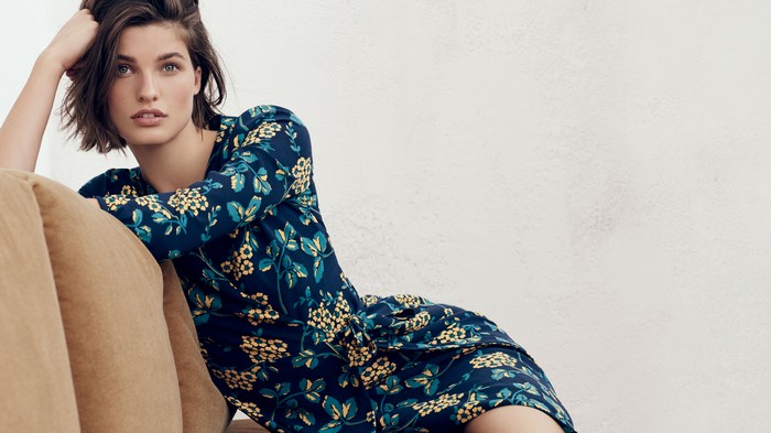 Model in a floral dress on a couch