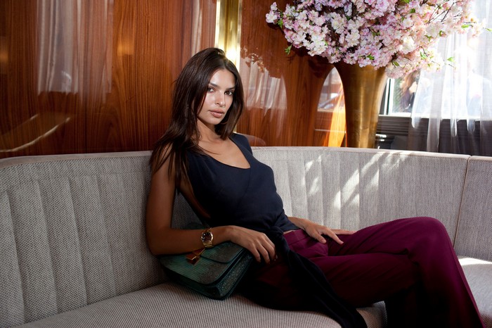Emily Ratajkowski sitting on a couch