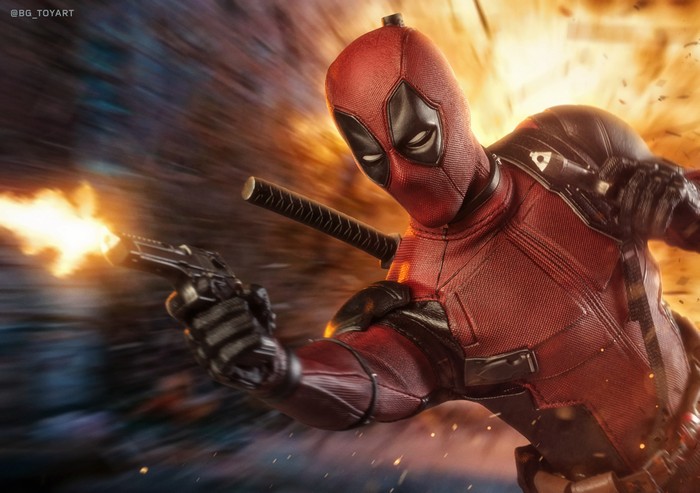 Deadpool firing a gun with explosions in the background