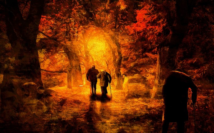 Two elderly people walking in an autumn park