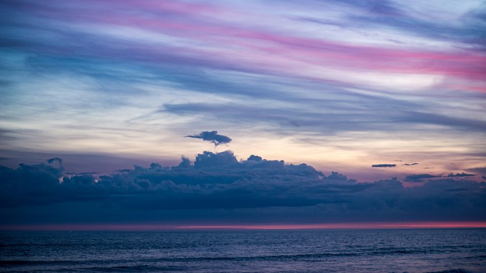 Ocean and clouds at sunset with pink and blue sky