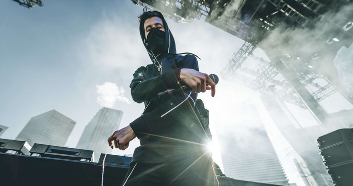 Alan Walker DJ performing on stage with city background