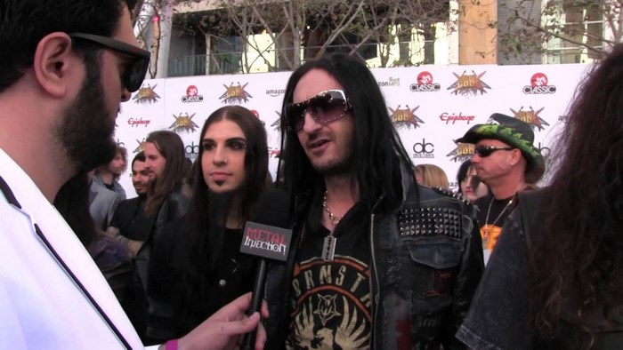Musicians on a red carpet with logos