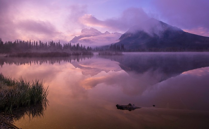 Sunrise over a misty lake with mountains