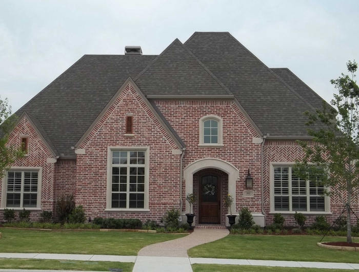 Brick house with arched entryway and large windows