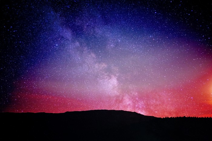 Milky Way galaxy over a silhouetted landscape