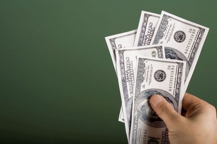 Hand holding US dollar bills