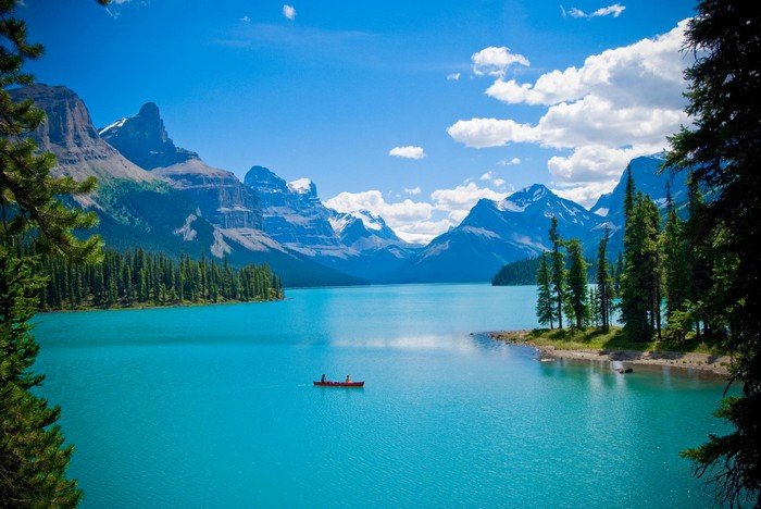 Turquoise lake with mountains and a canoe