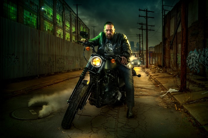 Man on Harley Davidson motorcycle in alley
