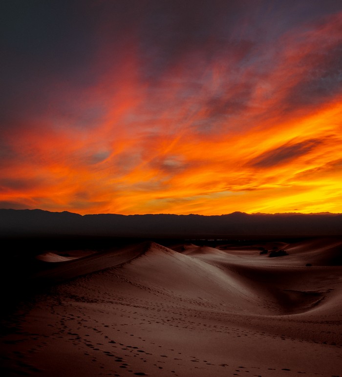 Desert dunes at sunset with dramatic sky