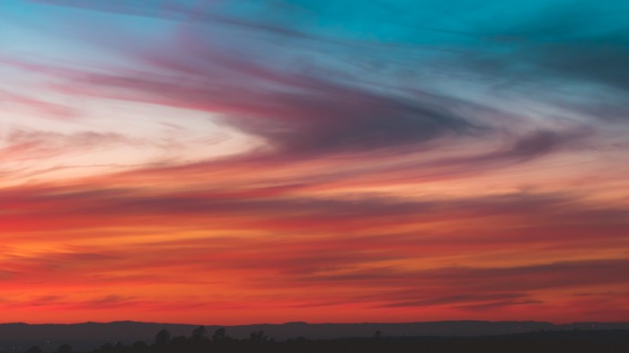 Sunset sky with colorful clouds and silhouetted landscape