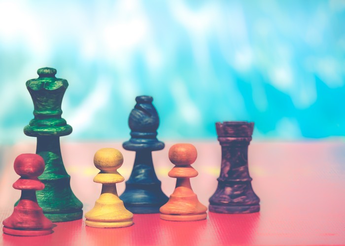 Chess pieces on a red board with a blue background