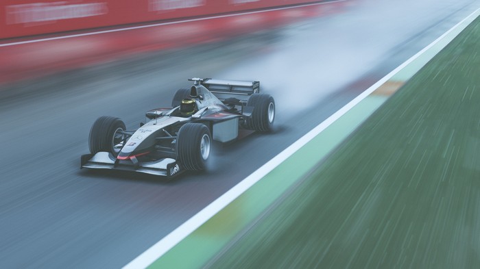 McLaren F1 car racing on a wet track