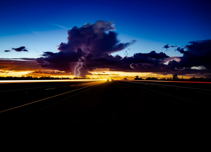 Lightning Storm Over Highway at Dusk