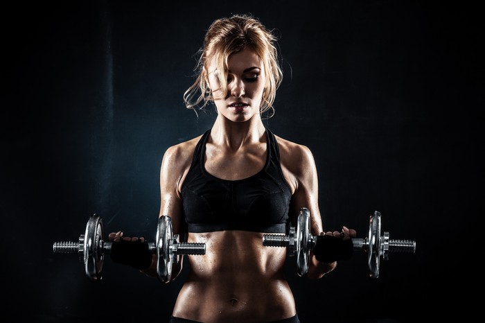 Woman exercising with dumbbells in a gym