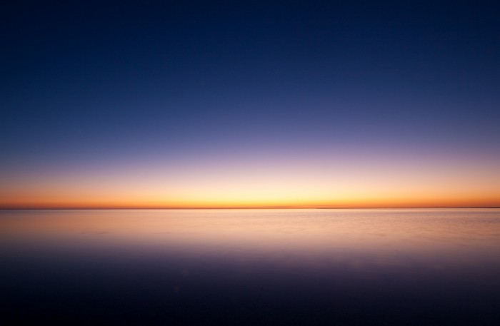 Minimalist ocean sunrise with gradient sky
