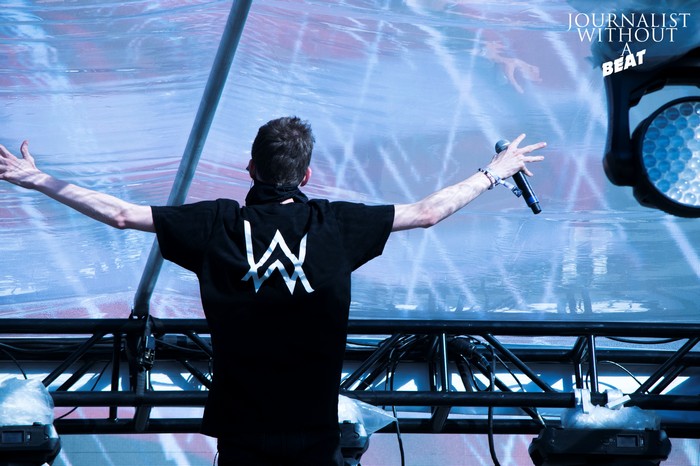 Alan Walker performing on stage with a microphone